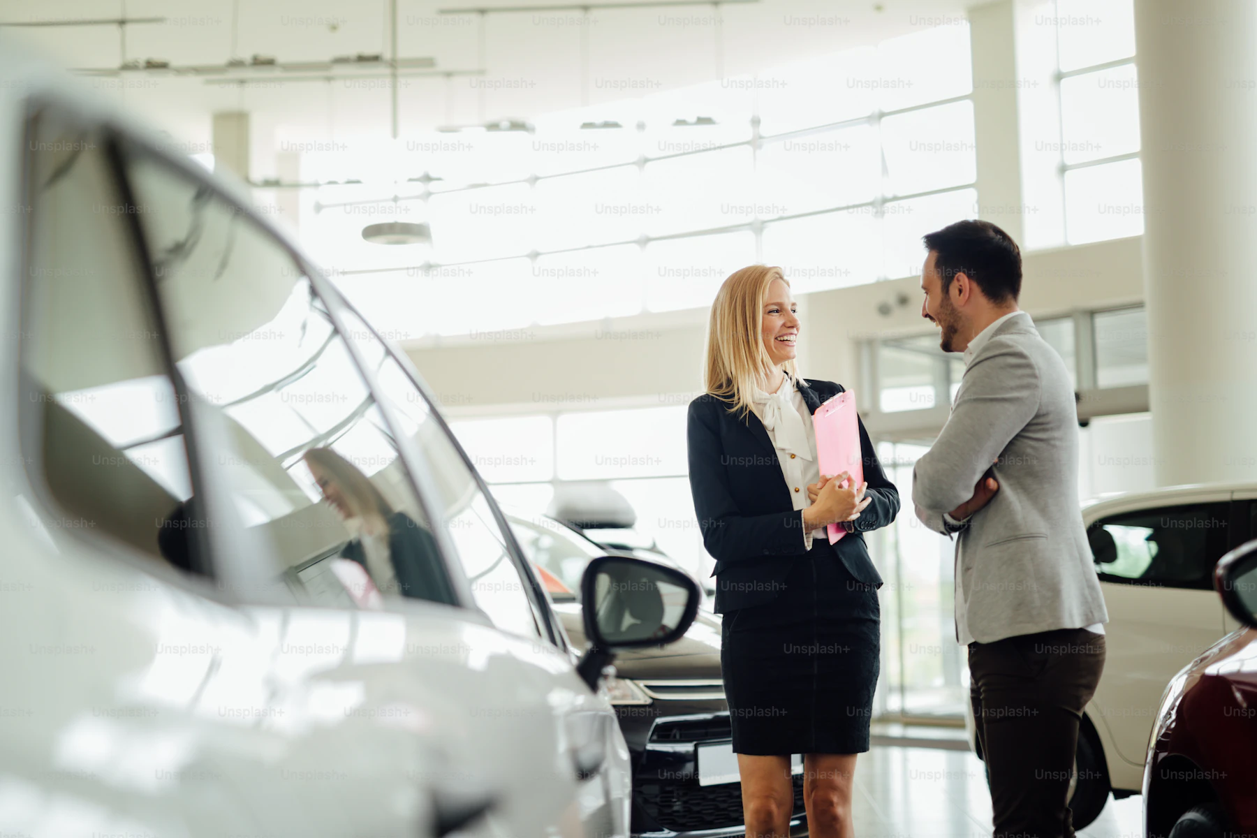 Sales staff talking with customers at the car dealership
