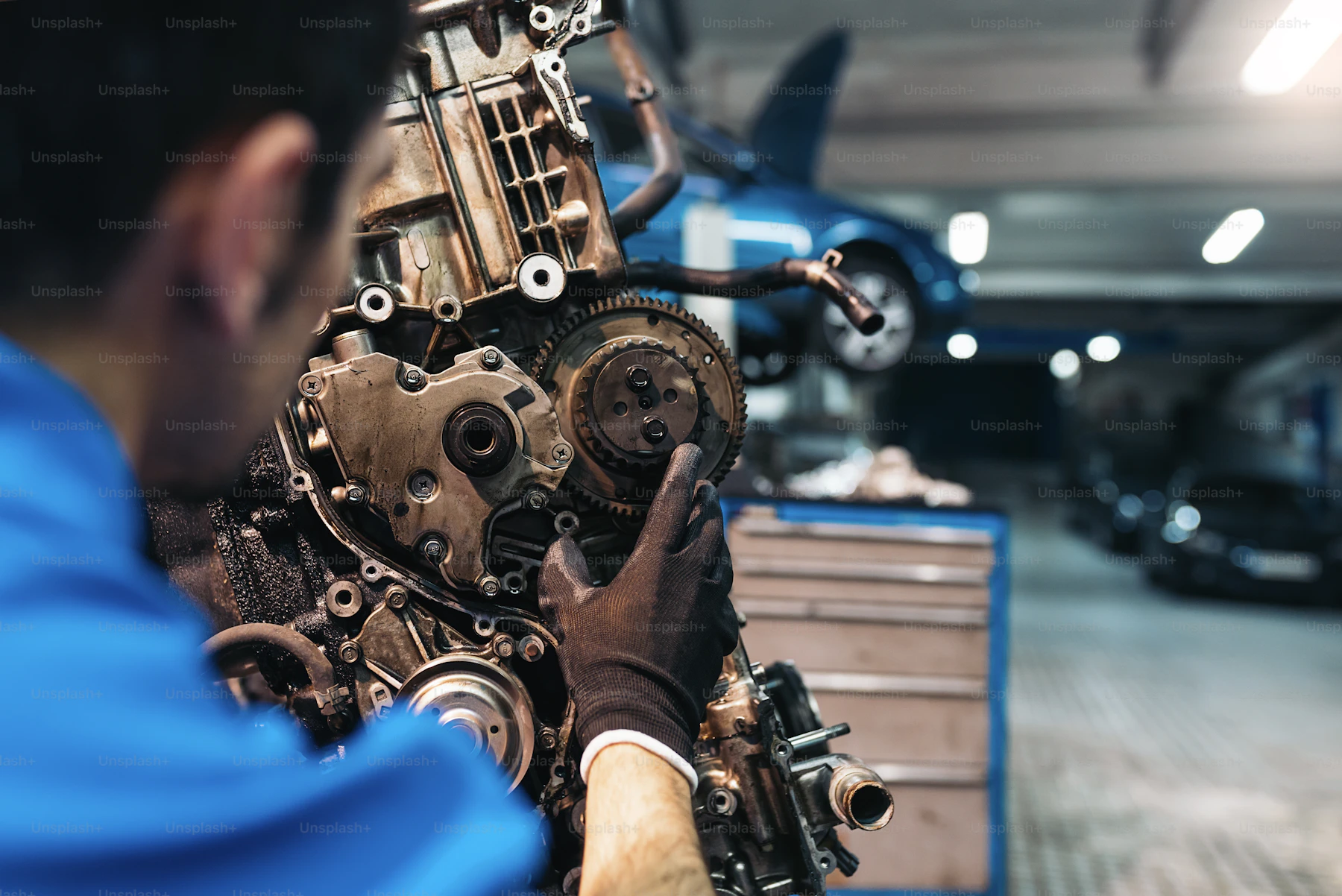 Professional mechanic repairing a car engine inside a garage